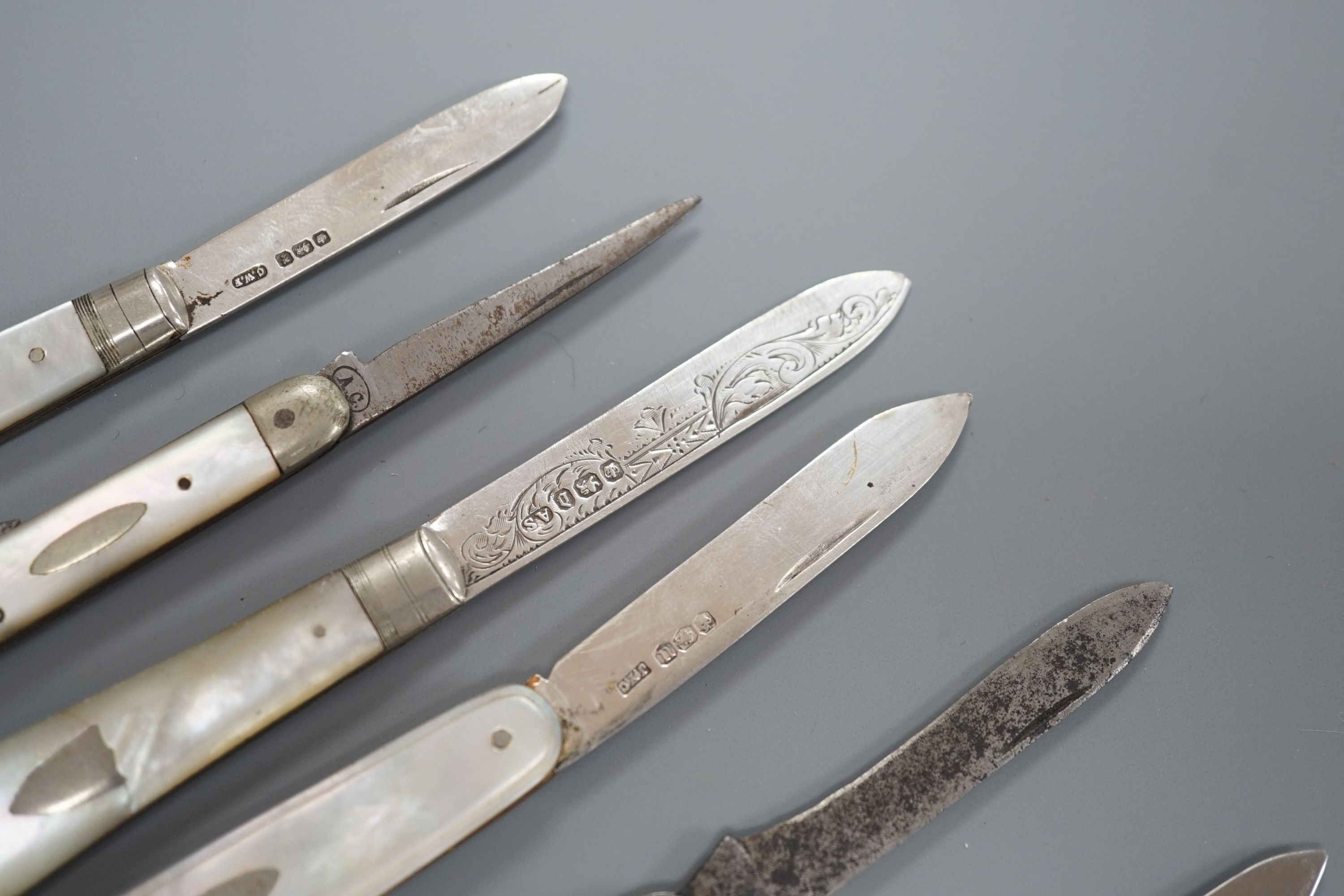 Three assorted mother of pearl mounted silver bladed fruit knives, one other penknife and two commemorative pocket knives.